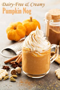 pumpkin nog in a glass mug with whipped cream and cinnamon on the top, surrounded by other ingredients