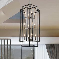 a chandelier hanging from the ceiling in a living room with windows and curtains