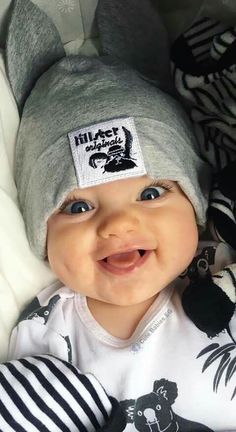 a smiling baby wearing a hat and pajamas