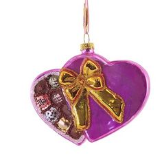 an ornament shaped like a heart with a cross on it and other decorations