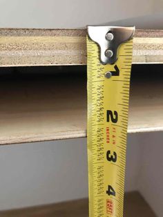 a measuring tape is hanging from the side of a shelf