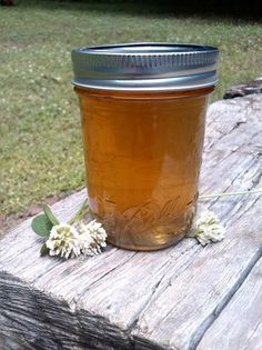 a jar filled with honey sitting on top of a wooden table