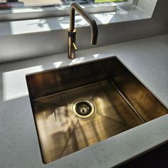 a stainless steel kitchen sink under a window