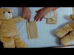 two teddy bears are laying on a bed with someone's hand over the top of them