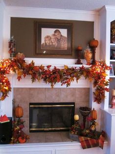 the fireplace is decorated with fall leaves and pumpkins