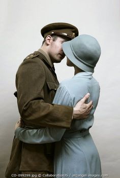 a man and woman dressed in uniforms kissing each other