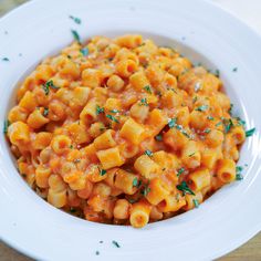 a white bowl filled with macaroni and cheese on top of a wooden table