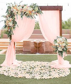 an outdoor wedding setup with pink drapes and flowers