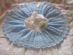 a crocheted blue and white blanket with a flower on it's center