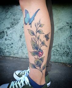 a person with a tattoo on their leg that has flowers and butterflies all over it