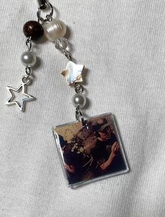 a keychain with a photo and charms attached to it on a white shirt