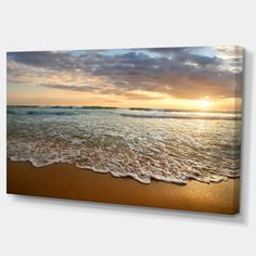 the sun is setting over the ocean with waves coming in to shore and clouds above