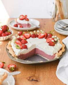 there is a cake with strawberries on the top and other desserts around it