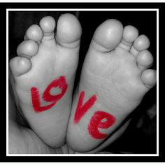 two feet with the word love painted on them and red paint in between them,