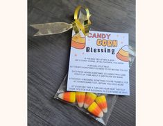 candy corn blessing bag with ribbon on wooden table next to it's label for candy corn blessing