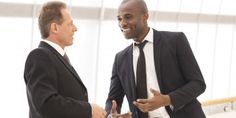 two men in suits talking to each other