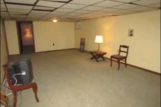 an empty room with two chairs and a television