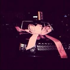 a pink ribbon tied to the hood of a car