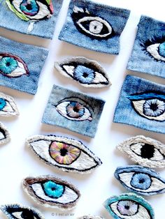 several pieces of denim with different colored eye patches on top of each other, all made out of blue jeans