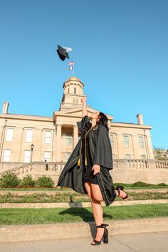 a woman in her graduation gown throwing a mortare into the air