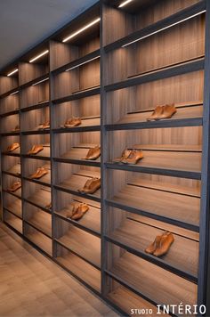 there are many wooden shelves with shoes on them