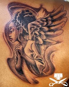 the back of a man's chest with an angel tattoo design on it and scissors