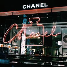 a chanel store front with neon lights