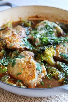 a dish with broccoli, meat and sauce in it sitting on a table