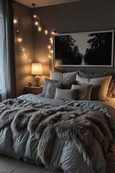 a large bed in a bedroom with lights on the headboard and blankets draped over it