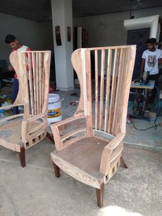 two wooden chairs sitting next to each other