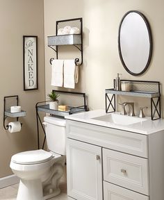 a white toilet sitting next to a sink in a bathroom under a mirror and shelves