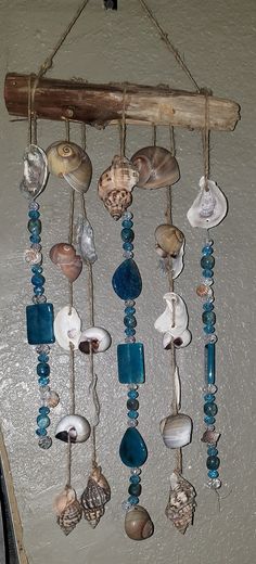 a wind chime with shells hanging from it's sides and blue glass beads