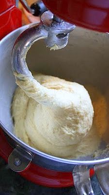 a red pot filled with dough on top of a stove