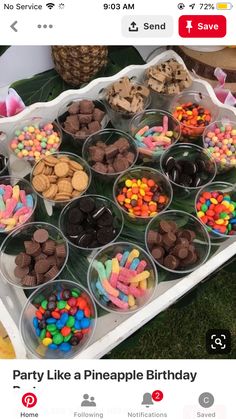 a table topped with lots of plastic cups filled with different types of candy and candies