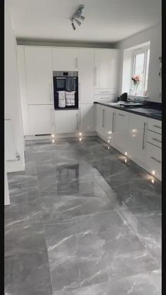 a kitchen with marble floors and white cabinets