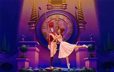 a man and woman dancing on stage in front of a clock