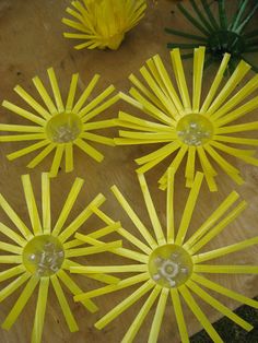 four yellow plastic flowers sitting on top of a wooden table