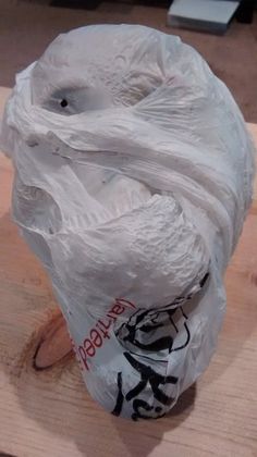 a plastic bag wrapped in white paper sitting on top of a wooden table