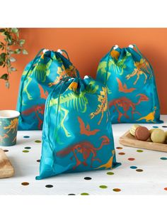 three bags sitting on top of a table filled with cookies and candy bar wrappers