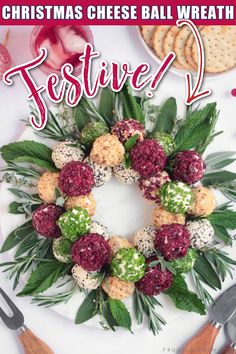 a christmas cheese ball wreath on a white plate with holiday decorations and utensils