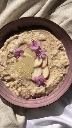 a bowl filled with oatmeal and sliced apples on top of a table