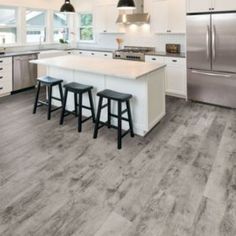 a kitchen with white cabinets and gray flooring