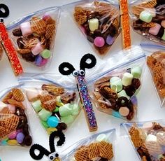 there are many snacks in the bags on the table with candy and candies around them