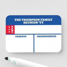 a family reunion card with a pen next to it on a white surface, the name and date are in red, white, and blue