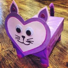 a paper bag with a cat's face on it sitting on top of a wooden floor