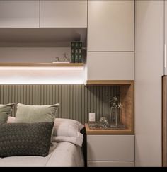 a bed sitting under a window next to a wooden shelf filled with vases and flowers