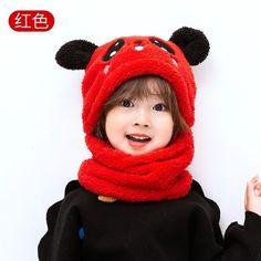 a young child wearing a red hat and scarf with ears on it's head