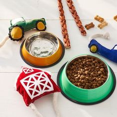 dog food and toys laid out on a white wooden table with a red barn toy