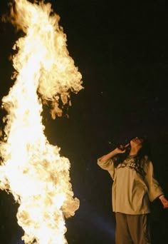 a man standing in front of a large fire