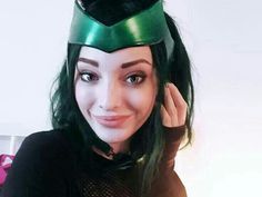 a woman with long hair wearing a green costume and a cat mask on top of her head